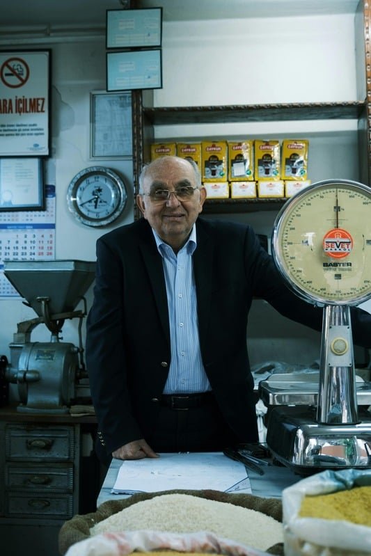 Smiling shop owner standing beside a scale