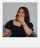 Seba laughing with her hand near her face